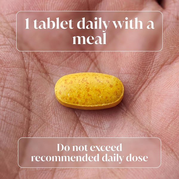 A yellow oval tablet resting on a person's palm, with text overlays reading '1 tablet daily with a meal' and 'Do not exceed recommended daily dose'.