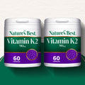 Two containers of Nature's Best Vitamin K2 on a white and green background