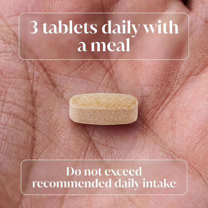 A single beige oval tablet resting on a person's palm, with overlaid text reading '3 tablets daily with a meal' and 'Do not exceed recommended daily intake'.