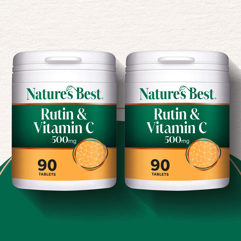 Two white plastic supplement bottles of Nature's Best Rutin & Vitamin C 500mg, each containing 90 tablets, displayed side-by-side on a dark green surface against a textured off-white background.