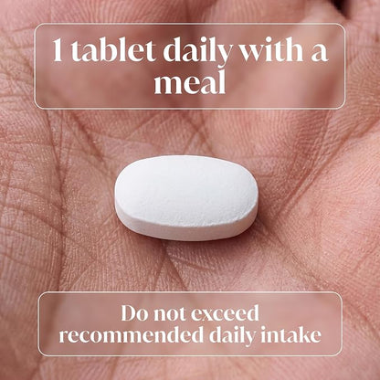 A white oval tablet resting on an open palm, with overlaid text reading '1 tablet daily with a meal' and 'Do not exceed recommended daily intake'.