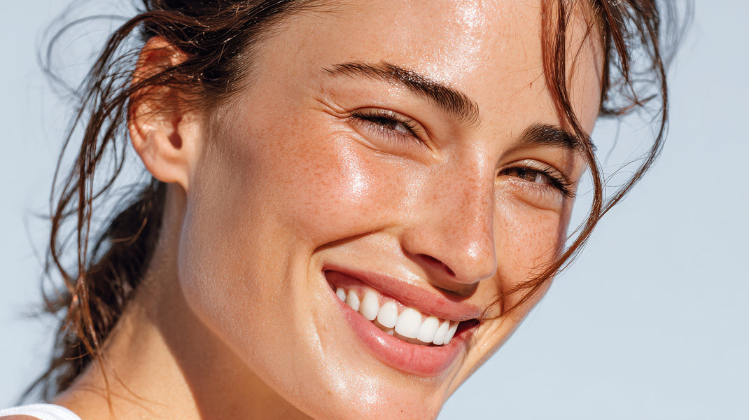 Close-up of a woman with a radiant smile against a light blue background