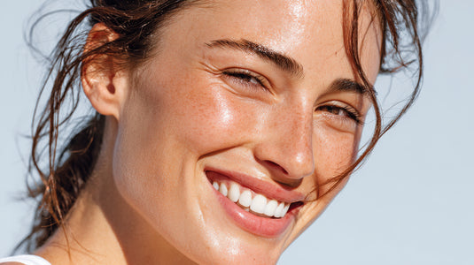 Close-up of a woman with a radiant smile against a light blue background