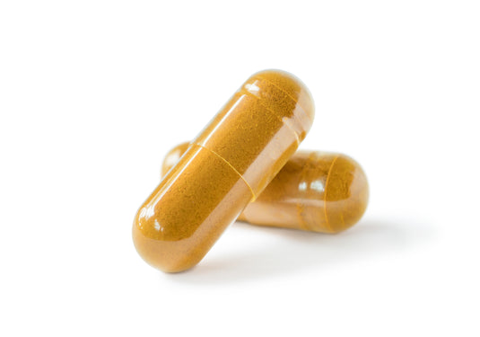 Two gold-colored capsules on a white background